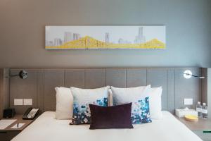 a bedroom with a bed with a yellow bridge painting on the wall at Capri by Fraser Brisbane in Brisbane