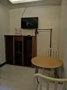 a room with a table and a flat screen tv at Cliffside Cottages in El Nido