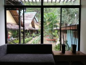 a living room with a couch and a large window at Cliffside Cottages in El Nido