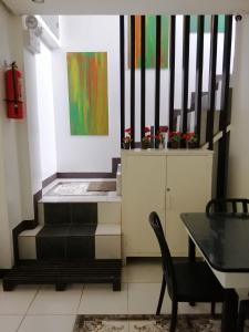 una habitación con escaleras, una mesa y una pintura en Cliffside Cottages, en El Nido