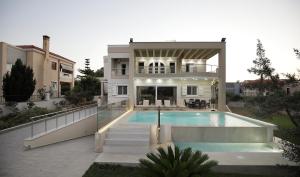 a large house with a swimming pool in front of it at Cedar Tree Villa in Kounoupidhianá