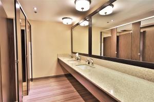 a bathroom with two sinks and two mirrors at Best Western Plus Montreal Downtown- Hotel Europa in Montréal