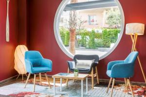 a room with three chairs and a round window at Best Western Plus Antibes Riviera in Antibes