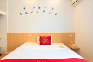 a bedroom with a bed with blue birds on the wall at China Town Hotel - SHA Plus Certified in Bangkok