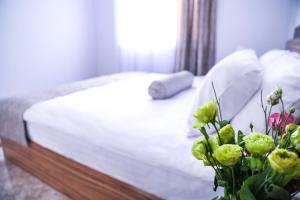 a bedroom with a bed and a vase with flowers at Garden Inn Resort Sevan in Sevan