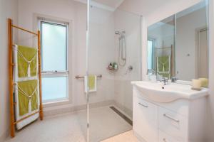 a white bathroom with a sink and a shower at Erriba House in Erriba