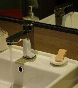a bathroom sink with a piece of bread on a plate at SSAW Boutique Hotel Hefei Intime Centre in Hefei