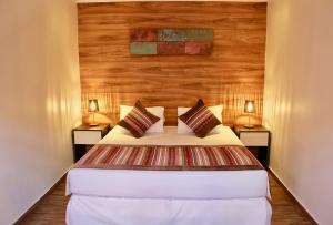 a bedroom with a bed with two lamps on both sides at Yakana Hotel in San Pedro de Atacama