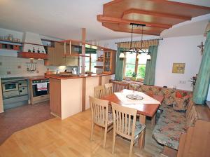 eine Küche und ein Wohnzimmer mit einem Tisch und Stühlen in der Unterkunft Ferienhaus Flatscher in Lofer