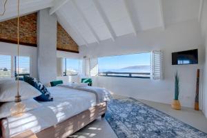 a bedroom with a large bed and a large window at Villa Sol in Wilderness