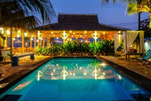 a swimming pool in front of a house at night at Sedjiwa in Gili Islands