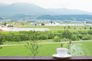 eine Tasse Kaffee auf einem Tisch mit Aussicht in der Unterkunft Furano Lookout in Nakafurano