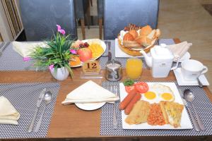 a table with a plate of breakfast food on it at Tiffany Diamond Hotels LTD - Makunganya in Dar es Salaam