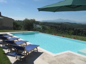 a swimming pool with chairs and an umbrella at Casale Le Borghe - Montalcino,Toscana in San Giovanni dʼAsso