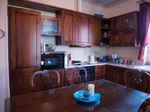 a kitchen with wooden cabinets and a table with chairs at Stone house in Khlóï