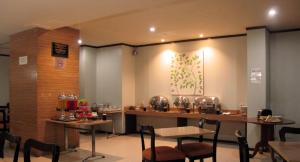 un ristorante con tavoli e sedie in una stanza di Hotel Alma a Giacarta