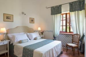 カプラローラにあるVilla la Paiola - Lago di Vicoのベッドルーム1室(ベッド1台、椅子、窓付)