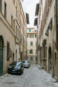 twee auto's geparkeerd in een steeg tussen gebouwen bij Historical stone house, in the amazing centre of Florence! in Florence