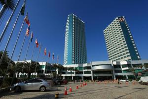 um carro estacionado em frente a um edifício com bandeiras em Pantower International Hotel em Kaiping