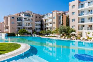 a swimming pool in front of some apartment buildings at Elysia Park in Paphos