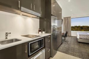 a kitchen with a sink and a refrigerator at Quest Kings Park in Perth