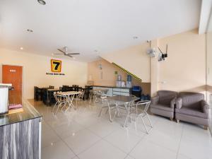un restaurante con mesas y sillas y un sofá en Super OYO 635 Seven Days Hotel en Raub