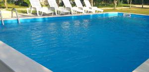 a swimming pool with chairs and blue water at Holiday Home Adna in Bihać