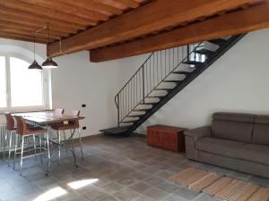 a living room with a table and a staircase at Il Fienile de La Cavallina in Larciano