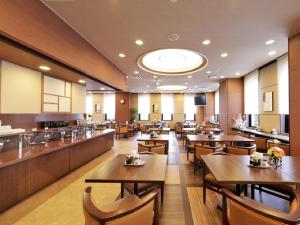 a restaurant with wooden tables and chairs and a bar at Hotel Route-Inn Sendaiizumi Inter in Sendai