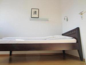 a bed with a wooden frame in a room at Hotel Sonderborg in Schrobenhausen