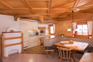 a kitchen with a wooden ceiling and a table at Appartements Stoffenhof in Alpbach