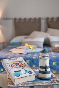 un libro e un faro su un tavolo con un letto di La Casa del Faro 31 a Napoli