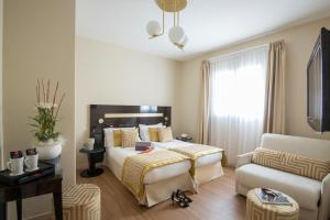 a hotel room with a bed and a couch at Hotel Carlton in Beaulieu-sur-Mer