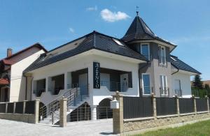 a large white building with a black roof at Alenso Guesthouse in Hévíz