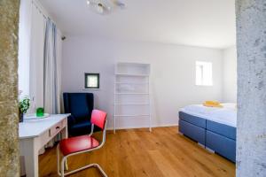 een slaapkamer met een bed, een bureau en een stoel bij Villa Breitenberg in Breitenberg
