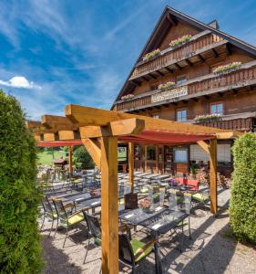 un groupe de tables et de chaises devant un bâtiment dans l'établissement Landgasthof Jostalstüble, à Titisee-Neustadt