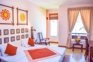 a bedroom with a bed and a table and a window at Insight Resort Ahangama - S&S Other Certified in Ahangama