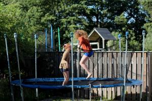 two young girls jumping on a trampoline at Villa M in Simrishamn
