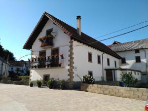 una casa blanca con flores en las ventanas en Casa Ayabe, en Jaurrieta