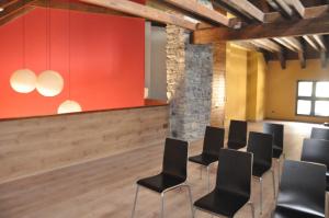a conference room with black chairs and a red wall at Ca Don Rafel in Castanesa