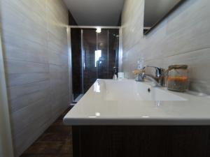 een badkamer met een witte wastafel en een douche bij Albergue Casa Manola in Abeleiras
