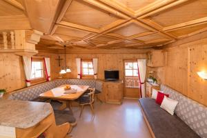 ein Wohnzimmer mit einer Holzdecke und einem Tisch in der Unterkunft Appartements Stoffenhof in Alpbach
