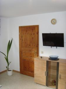 un soggiorno con TV e mobile in legno di Ferienwohnung Ina a Rust