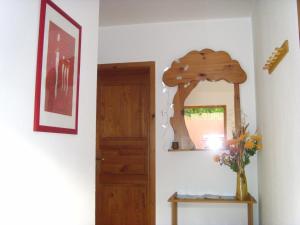 un couloir avec un miroir et une table avec un vase de fleurs dans l'établissement Ferienwohnung Ina, à Rust