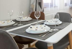 stół z talerzami i kieliszkami do wina w obiekcie Ormani Modern Stúdióapartman w mieście Pecz