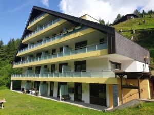 Ein Gebäude mit Leuten, die auf den Balkonen sitzen in der Unterkunft Mountain apartment Innerkrems in Innerkrems