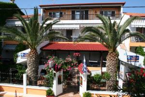 a hotel with palm trees in front of it at Haus Maria in Nea Potidaea