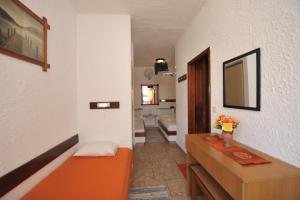 a room with an orange couch and a bathroom at Haus Maria in Nea Potidaea