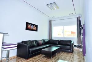 a living room with a black couch and a window at Appart Clim Wifi 700m de la Plage in Saïdia