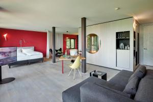 a living room with a couch and a bed at Sorell Hotel Rigiblick - Studios & Spa Suites in Zürich +27 photos